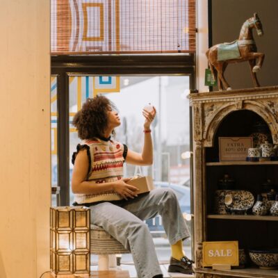 Brunette Woman Sitting by Window in Store